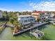 Waterfront home with a dock and boat lift surrounded by lush landscaping at 1201 Bay Dr, Belleair Beach, FL 33786