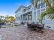A stunning two-story home featuring a stone patio with water feature, outdoor seating and large windows for natural light at 1201 Bay Dr, Belleair Beach, FL 33786