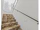 Granite staircase featuring glass block window and wrought iron railing, offering a modern yet elegant touch at 1201 Bay Dr, Belleair Beach, FL 33786