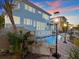Evening view of a home's water feature, pool, and elegant outdoor lighting at 1201 Bay Dr, Belleair Beach, FL 33786