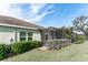 Backyard view showcases the screened-in patio, manicured shrubs, green lawn, and seamless blend of indoor-outdoor living at 13573 Circa Crossing Dr, Lithia, FL 33547