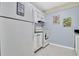 Cozy kitchen featuring white cabinets, appliances, tile floors and light blue walls at 14130 Rosemary Ln # 3203, Largo, FL 33774