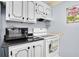 This kitchen features white cabinets, granite countertop, and modern appliances at 14130 Rosemary Ln # 3203, Largo, FL 33774