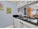 This kitchen features black countertop and view to dining area at 14130 Rosemary Ln # 3203, Largo, FL 33774