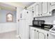 Cozy kitchen featuring white cabinets, appliances, tile floors and light blue walls at 14130 Rosemary Ln # 3203, Largo, FL 33774