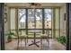 A sunroom with windows featuring travertine floors and an outdoor view at 14130 Rosemary Ln # 3203, Largo, FL 33774