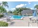 A large community pool with plenty of lounge chairs for relaxing under the palms trees at 14130 Rosemary Ln # 3203, Largo, FL 33774