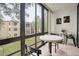 Bright sunroom features walls of windows offering outside views, a neutral tile floor and seating for two at 14130 Rosemary Ln # 3203, Largo, FL 33774