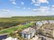 Aerial view of a golf course, buildings, parking, and the waterfront in the background at 14820 Rue De Bayonne # 205, Clearwater, FL 33762