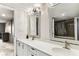 Bathroom with double sinks, decorative mirrors, and vanity with drawers and cabinets at 14820 Rue De Bayonne # 205, Clearwater, FL 33762