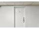 Hallway white entry door with gold hardware and unit number, complemented by neutral walls and tiled floor at 14820 Rue De Bayonne # 205, Clearwater, FL 33762