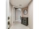 Welcoming home entryway with a decorative cabinet, round mirror, and neutral color scheme at 14820 Rue De Bayonne # 205, Clearwater, FL 33762