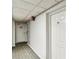 Hallway with unit door, emergency exit, and carpet, highlighting building safety and access at 14820 Rue De Bayonne # 205, Clearwater, FL 33762