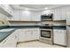 Functional kitchen featuring stainless steel appliances, white cabinets, and practical design at 14820 Rue De Bayonne # 205, Clearwater, FL 33762