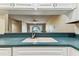 View of the kitchen sink area looking out to the living room, with its fan and sliding glass doors at 14820 Rue De Bayonne # 205, Clearwater, FL 33762