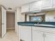 Well-lit kitchen with sleek white cabinets, open layout, and modern dishwasher at 14820 Rue De Bayonne # 205, Clearwater, FL 33762