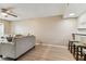 Living room with a couch, ceiling fan, breakfast bar with 3 barstools, and light colored wood flooring at 14820 Rue De Bayonne # 205, Clearwater, FL 33762