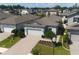 Aerial view of a home with a brick paver driveway and mature landscaping in a community with solar panels at 20092 Stone Pine Cir, Lutz, FL 33558