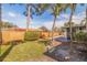 Grassy backyard features a tall wooden fence, mature trees and landscaping at 2031 Tanglewood Ne Way, St Petersburg, FL 33702