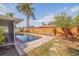 A backyard pool is surrounded by a brick patio, wooden fence and lush landscaping at 2031 Tanglewood Ne Way, St Petersburg, FL 33702