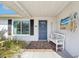 Entrance to a charming single Gathering home with a white bench and nautical décor by the front door at 2034 Scotland Dr, Clearwater, FL 33763