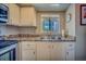 Galley kitchen featuring stainless steel appliances, stone countertops, and shaker style white cabinets at 215 Valencia Blvd # 207, Belleair Bluffs, FL 33770