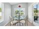 Bright breakfast nook with large windows and a glass table with seating for four at 2226 Indian Key Dr, Holiday, FL 34691