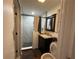 Compact bathroom featuring a shower with marble tiling and a dark vanity with a stylish dark-stained mirror at 3112 Desoto Rd, Sarasota, FL 34234