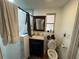 Compact bathroom featuring a shower with marble tiling and a dark vanity with a stylish dark-stained mirror at 3112 Desoto Rd, Sarasota, FL 34234
