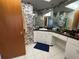 Bathroom with vanity, sink, and drawers, complemented by bamboo wallpaper and a decorative mirror at 3112 Desoto Rd, Sarasota, FL 34234