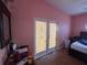A bright bedroom with wood floors leads out to the backyard through a door and features a small dresser at 3112 Desoto Rd, Sarasota, FL 34234