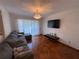 Living room with couch, television, chandelier, and hardwood floors at 3112 Desoto Rd, Sarasota, FL 34234