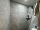 Modern shower design with light-colored marble tiling and a shower head with a matching shelf at 3112 Desoto Rd, Sarasota, FL 34234