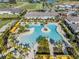 Aerial view showcasing a resort-style community pool surrounded by palm trees and amenities at 31837 Cannon Rush Dr, San Antonio, FL 33576