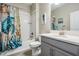 Well-lit bathroom features a shower-tub combo with seashell-themed curtain and a stylish gray vanity at 31837 Cannon Rush Dr, San Antonio, FL 33576