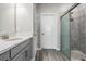 Bathroom with a tiled walk-in shower, gray cabinets, and a sink with chrome faucet at 31837 Cannon Rush Dr, San Antonio, FL 33576