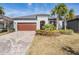Charming single-story home with a brick driveway, manicured landscaping, and a two-car garage at 31837 Cannon Rush Dr, San Antonio, FL 33576
