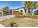 Beautiful single-story home featuring a well-manicured lawn, palm trees and a brick paved driveway at 31837 Cannon Rush Dr, San Antonio, FL 33576