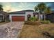 Charming single-story home featuring a brick driveway, a two-car garage, and a well-manicured front yard at 31837 Cannon Rush Dr, San Antonio, FL 33576