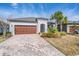 Charming single-story home with a brick driveway, two car garage, and beautifully landscaped front yard at 31837 Cannon Rush Dr, San Antonio, FL 33576