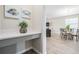 Hallway features a desk with decorative artwork, leading to the living and dining areas at 31837 Cannon Rush Dr, San Antonio, FL 33576