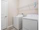 Modern laundry room equipped with a new washer, dryer, and a convenient storage shelf above at 31837 Cannon Rush Dr, San Antonio, FL 33576