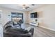 Inviting living room features a large sectional sofa, sliding glass doors to the backyard, and gray flooring at 31837 Cannon Rush Dr, San Antonio, FL 33576