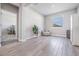 Bright living room featuring wood flooring, and an armchair by a window and a view of the main bedroom at 31837 Cannon Rush Dr, San Antonio, FL 33576