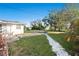 Spacious backyard with a well-maintained lawn, landscaping, and patio seating at 3218 Fauna St, Sarasota, FL 34235