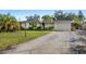 Charming single-story home with lush landscaping, palm trees, and an attached one car garage at 3218 Fauna St, Sarasota, FL 34235