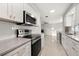 Updated kitchen features stainless steel appliances, gray counters, and white cabinetry at 3218 Fauna St, Sarasota, FL 34235