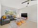 Bright living room with a comfy gray sofa, plush rug, and lots of natural light from the big windows at 3218 Fauna St, Sarasota, FL 34235