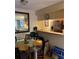 Dining area with a glass table, chairs, and view into the living room and kitchen at 3265 Beneva Rd # 202, Sarasota, FL 34232