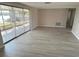 Spacious living room features durable laminate floors and sliding glass doors to a screened patio at 3320 Jackson Dr, Holiday, FL 34691